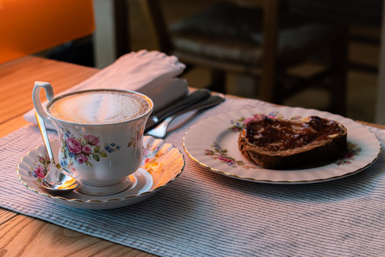 Elegant breakfast scene with vintage floral china coffee cup and jam toast on table in San Bonifacio.